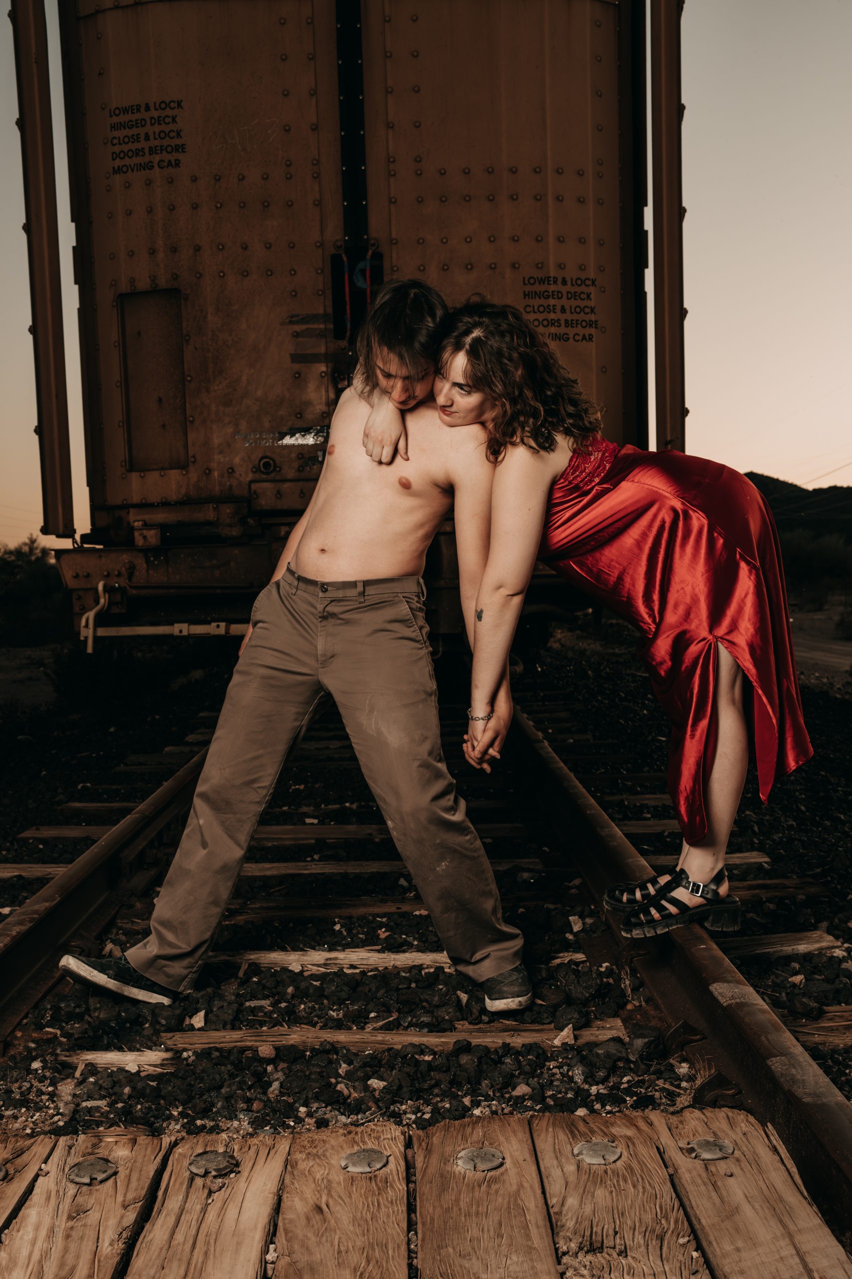 Outdoor boudoir photo of couple in warm Arizona sunset light near Buckeye ranch